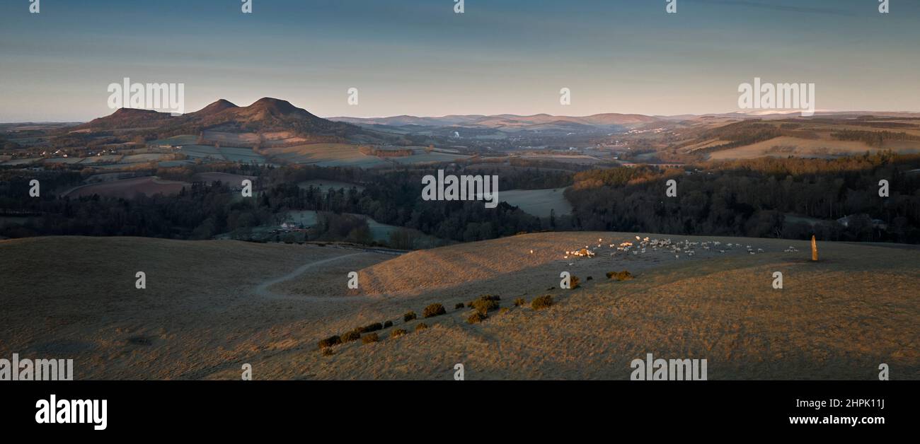 Aerial shot from drone of a standing stone and the Eildon Hills in the Scottish Borders at sunrise on a bright February day. Stock Photo
