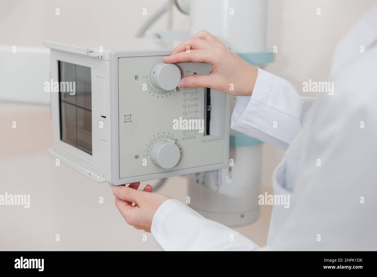 Hospital Radiology Room. Xray machine for fluorography. Doctor radiologist in gown adjusting the