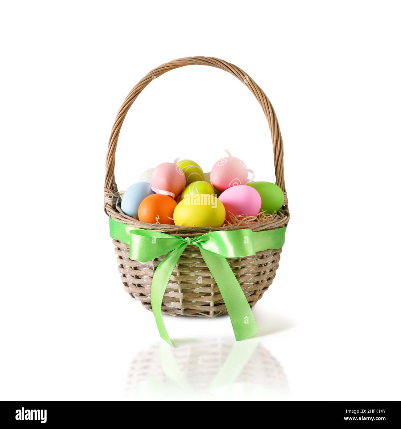 Easter wicker basket with pastel colorful eggs isolated on white