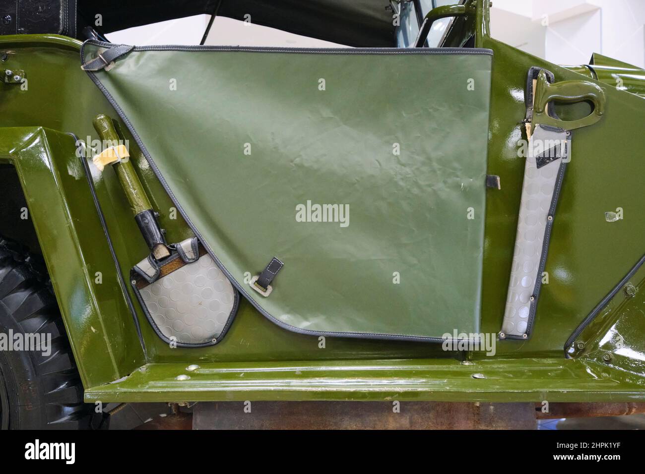 A shovel and saw mounted by the soft door of a Gaz-67 green military small jeep transport car, vehicle. At the Polytechnical, Polytexnika Transportati Stock Photo