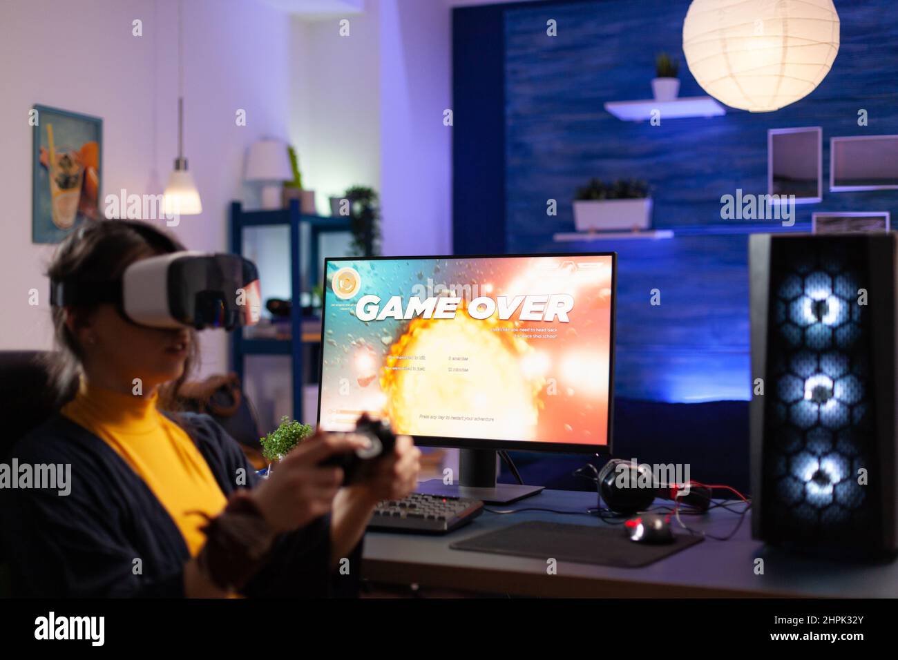 Player with vr headset losing video games on computer. Woman playing game with controller and virtual reality headset on pc monitor. Person lost online game with goggles and joystick. Stock Photo