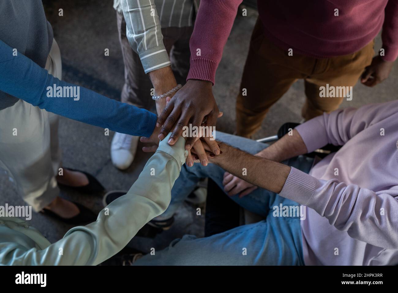 Above angle of pile of hands of contemporary intercultural employees in smart casualwear standing in front of one another Stock Photo