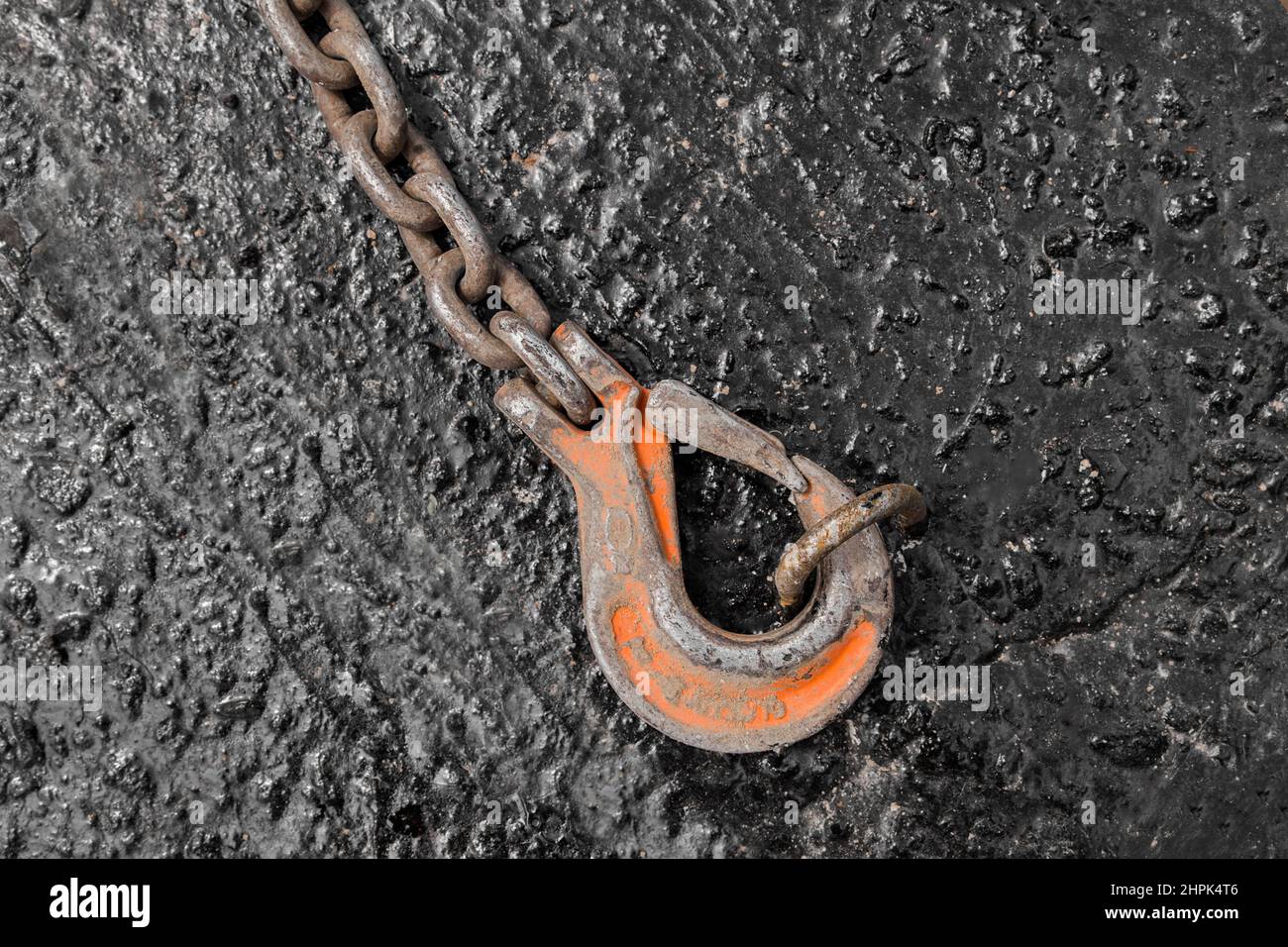 Iron hoist tool hook load heavy lifting weight sling mechanism chain fixed on concrete structure. Stock Photo