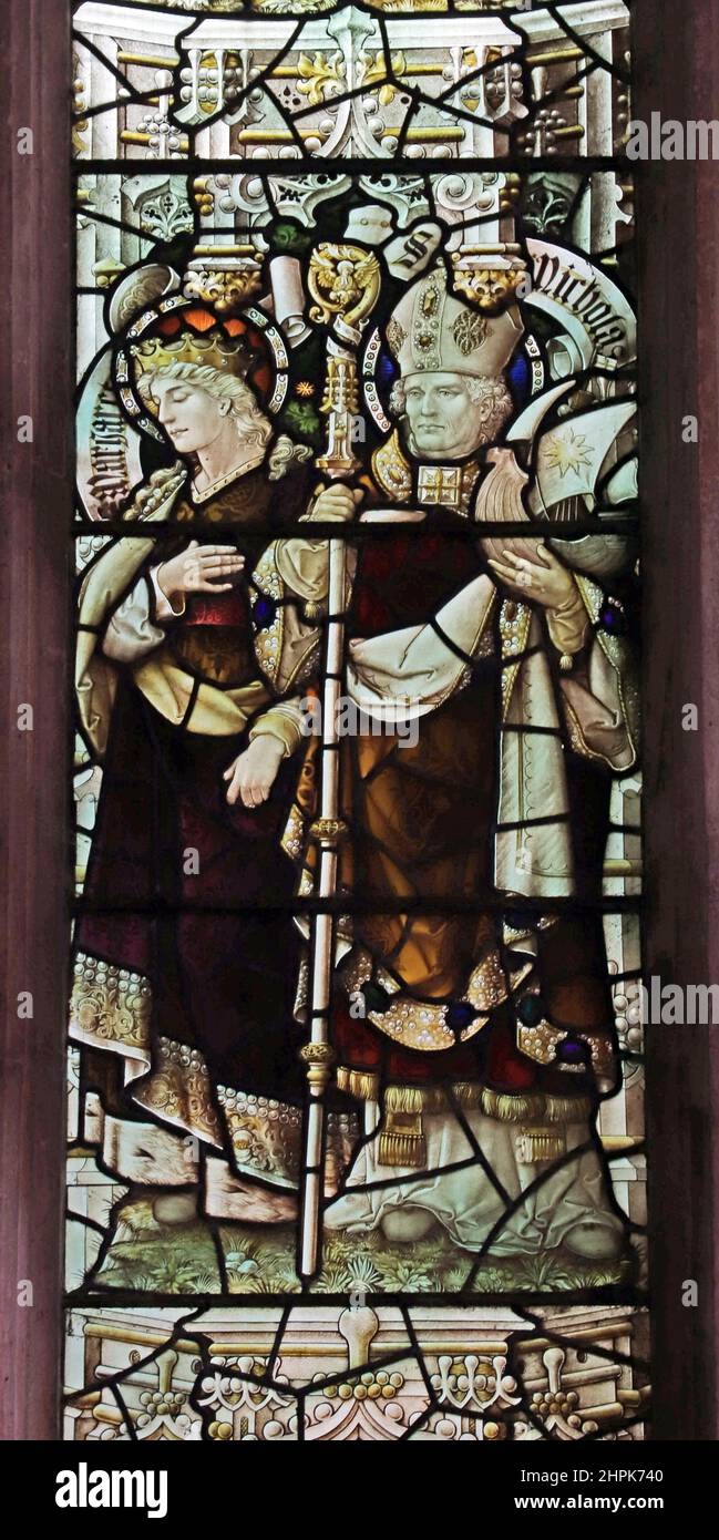 Stained glass window by Percy Bacon & Brothers depicting Saints Margaret and Nicholas, St. Peter and St. Paul's Church, Watlington, Norfolk Stock Photo