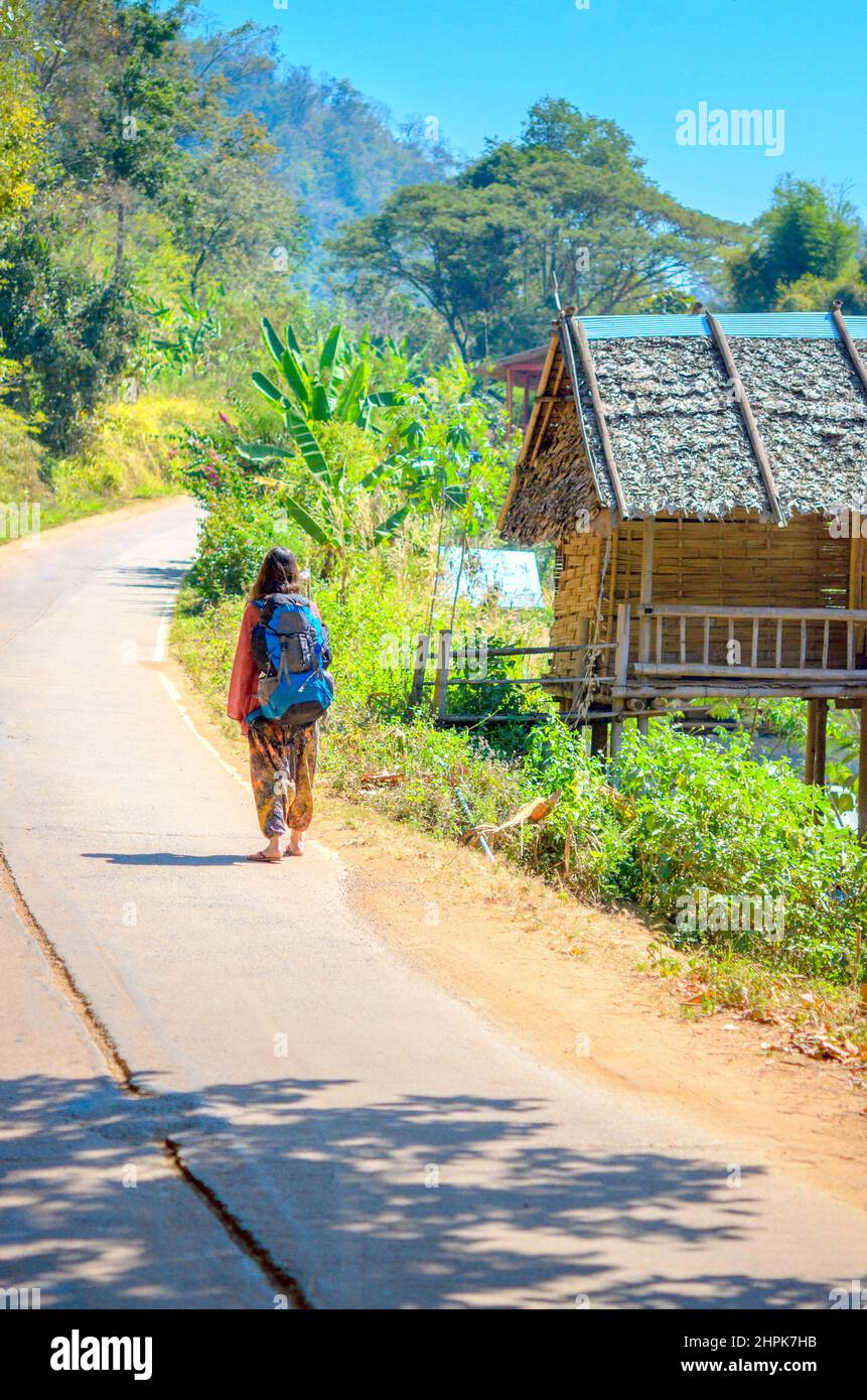 girl traveler walking along the road with a backpack Stock Photo