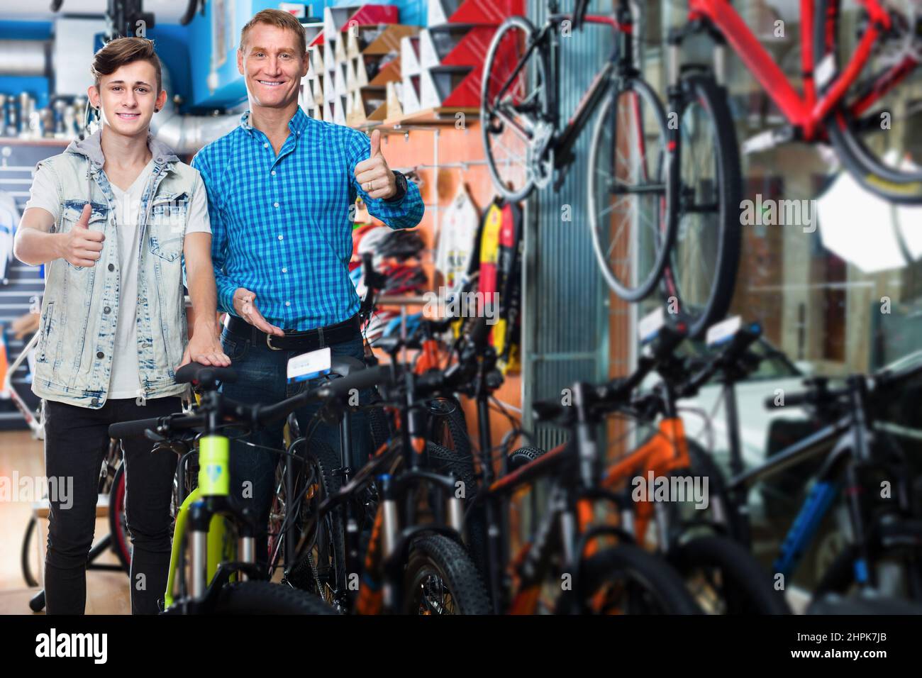 Man and boy holding thumbs up while buying new bicycle Stock Photo