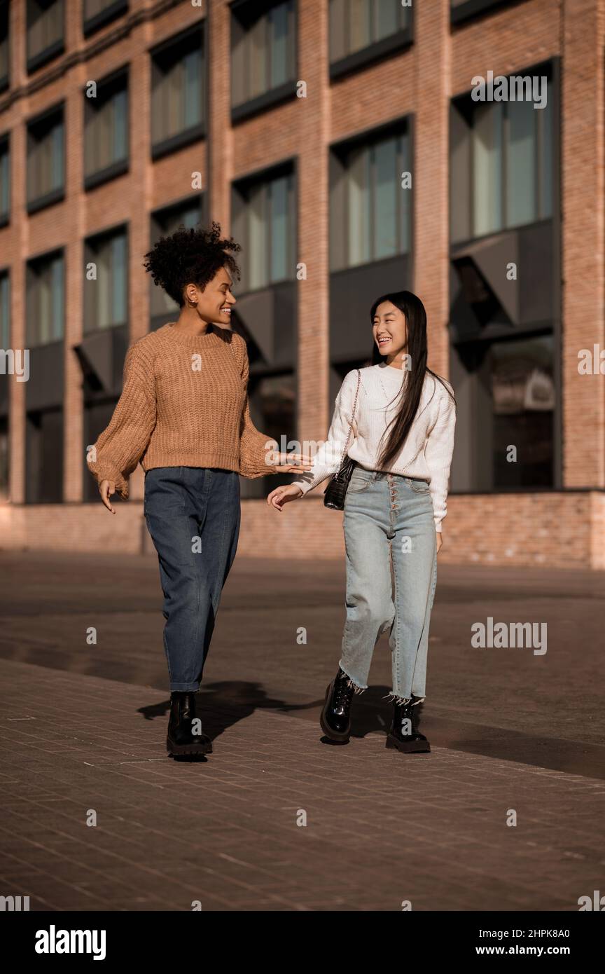 Two cute girls walking together in the street Stock Photo - Alamy