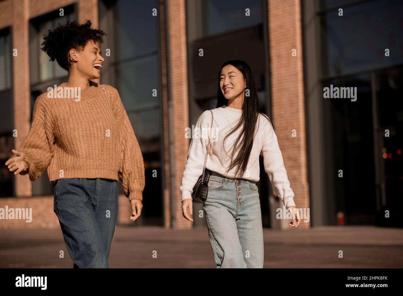 Two cute girls walking together in the street Stock Photo - Alamy