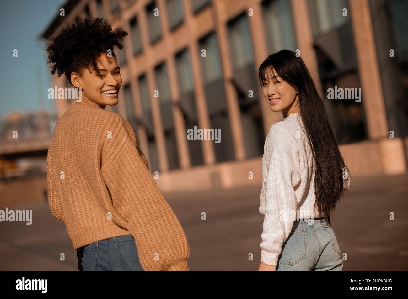 Two cute girls walking together in the street Stock Photo - Alamy