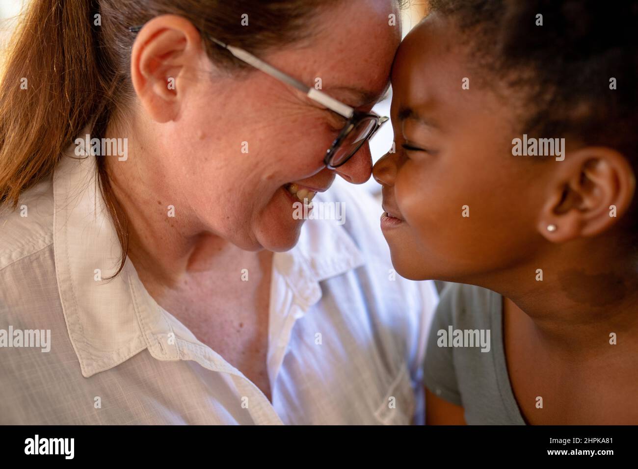 Close up Of Smiling Caucasian Mature Mother And African American Girl close-up-of-smiling-caucasian-mature-mother-and-african-american-girl