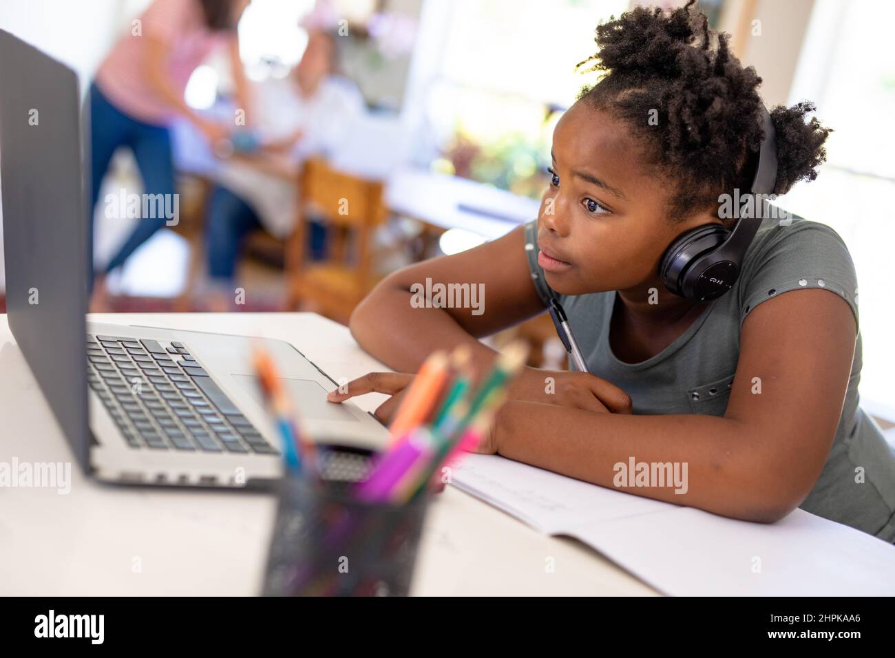African american girl wearing headphone using laptop during online ...