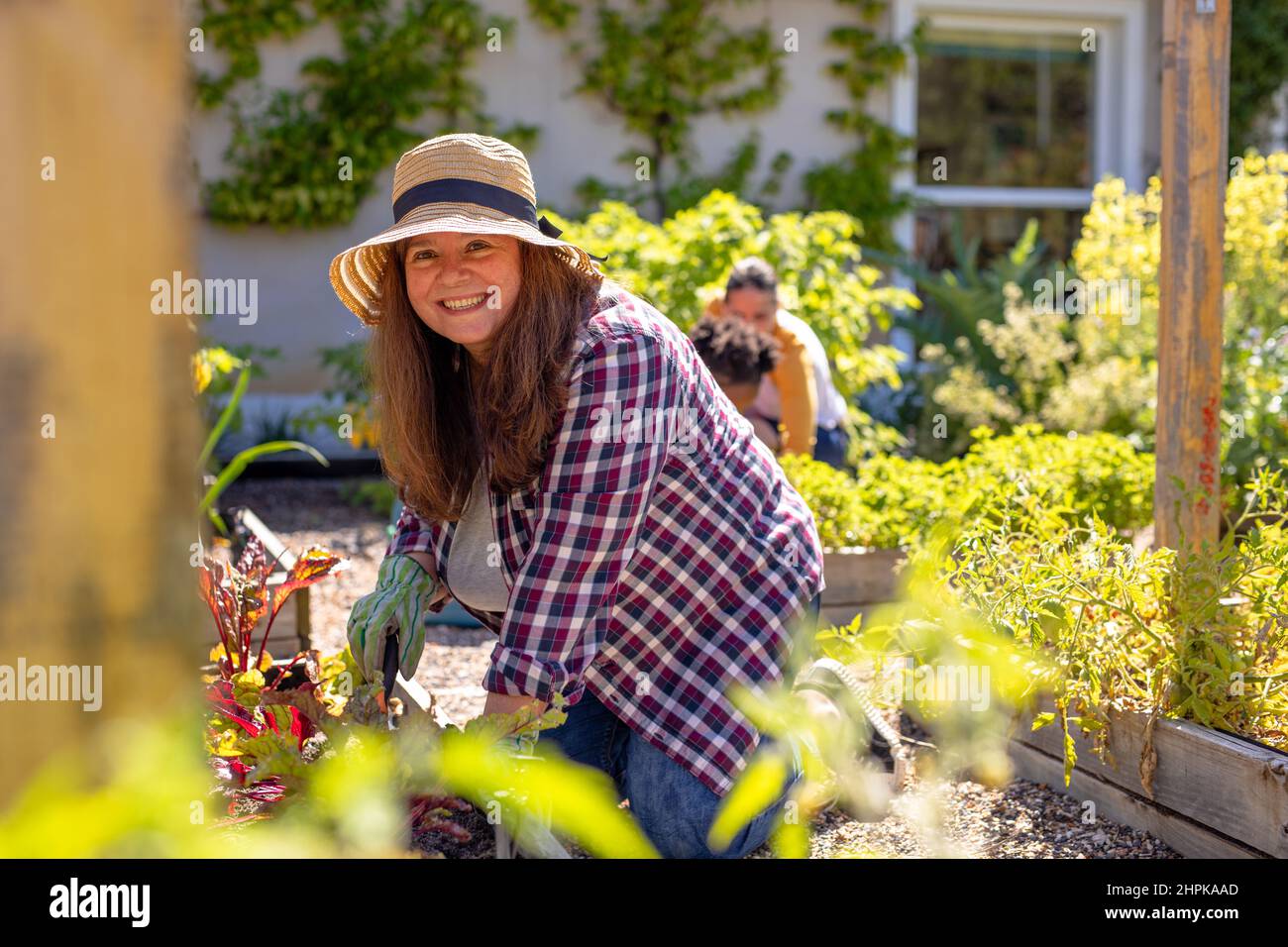 Portrait of smiling caucasian mature woman gardening in vegetable garden Stock Photo