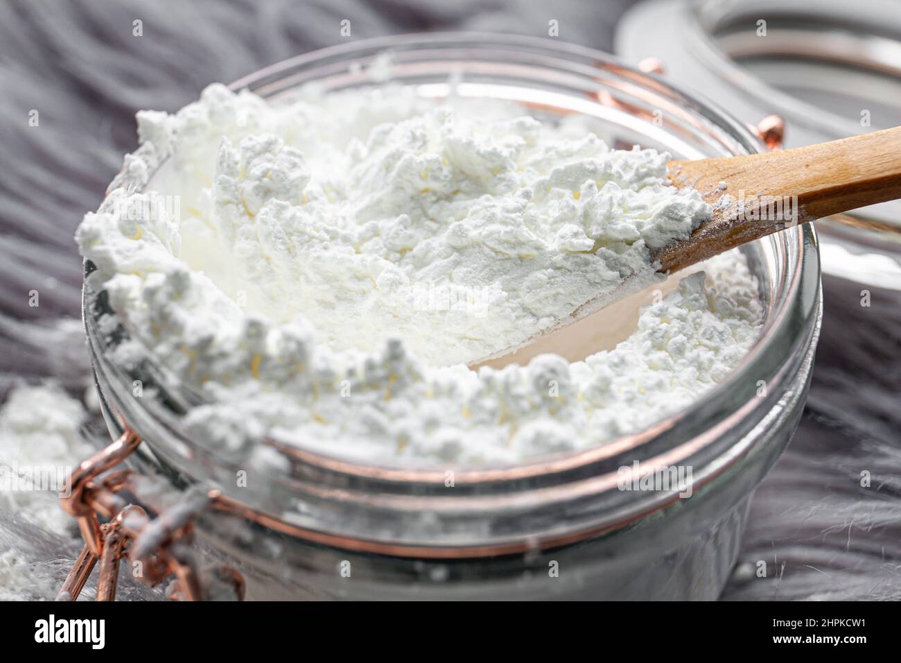 Woman hand pouring corn starch cornflour powder on long hair fur carpet