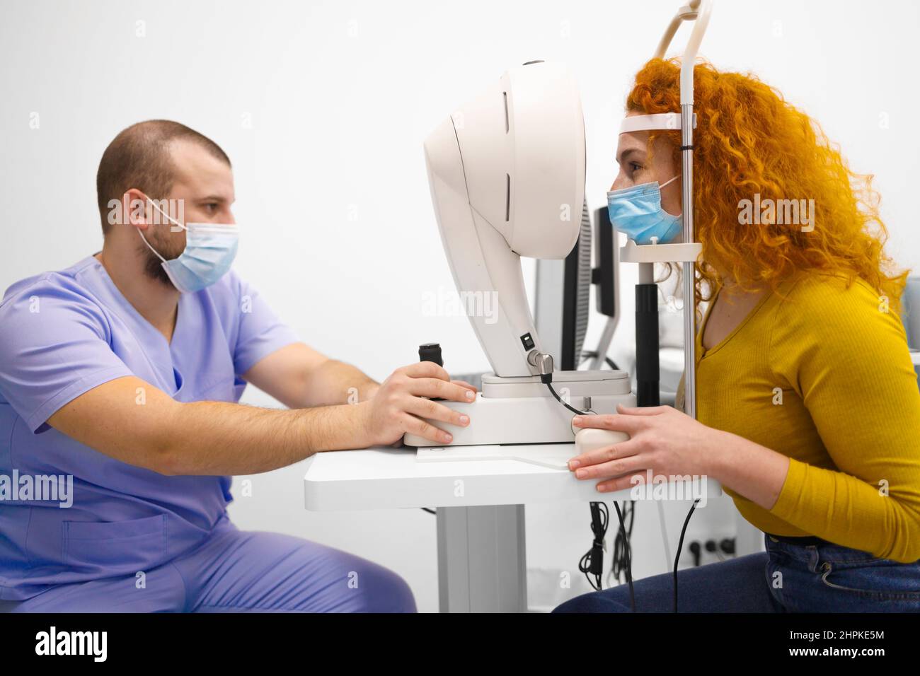 A technician and a customer during a regular eye exam Stock Photo