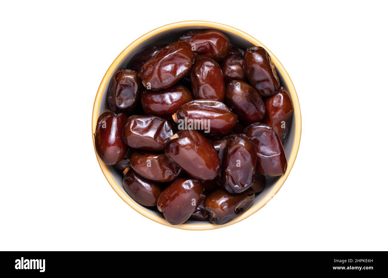Full bowl of dried dates isolated on white. Stock Photo