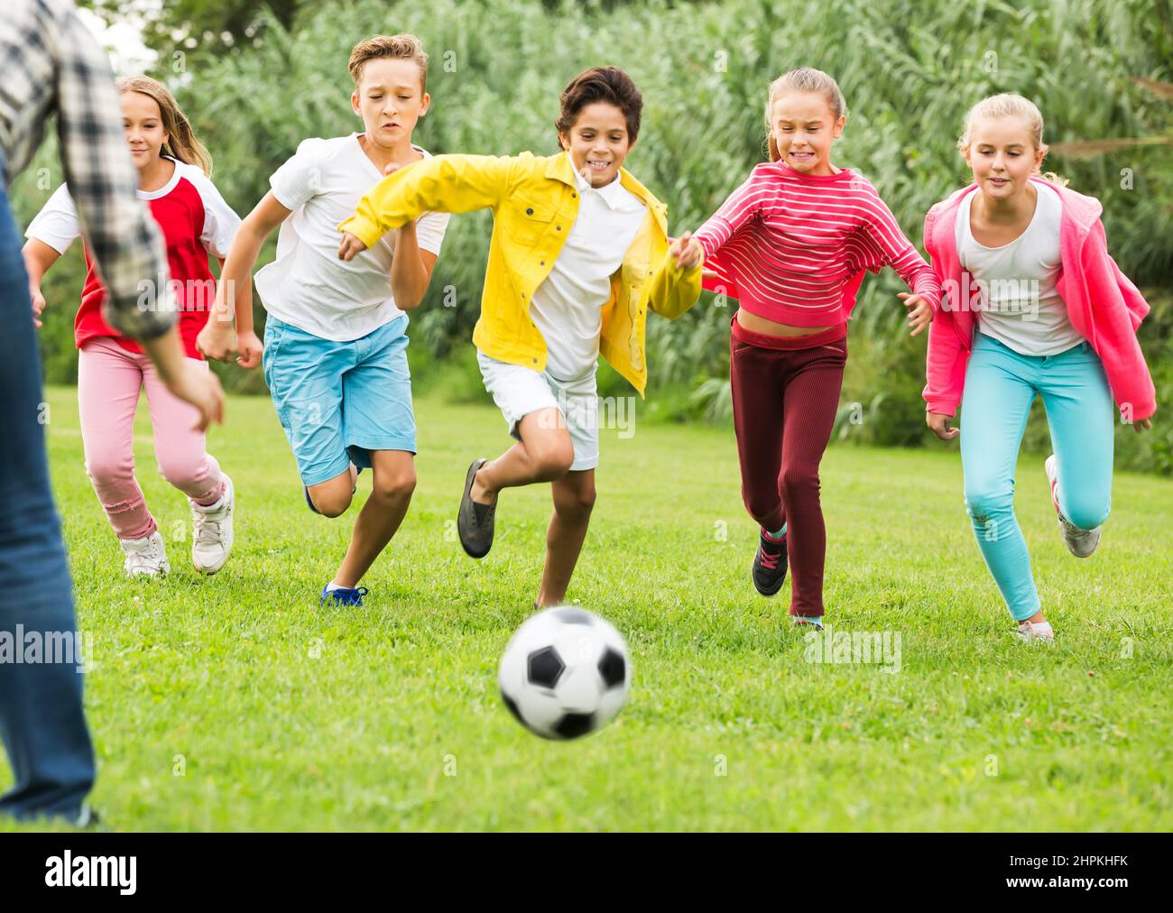 Kids playing football in park Stock Photo - Alamy