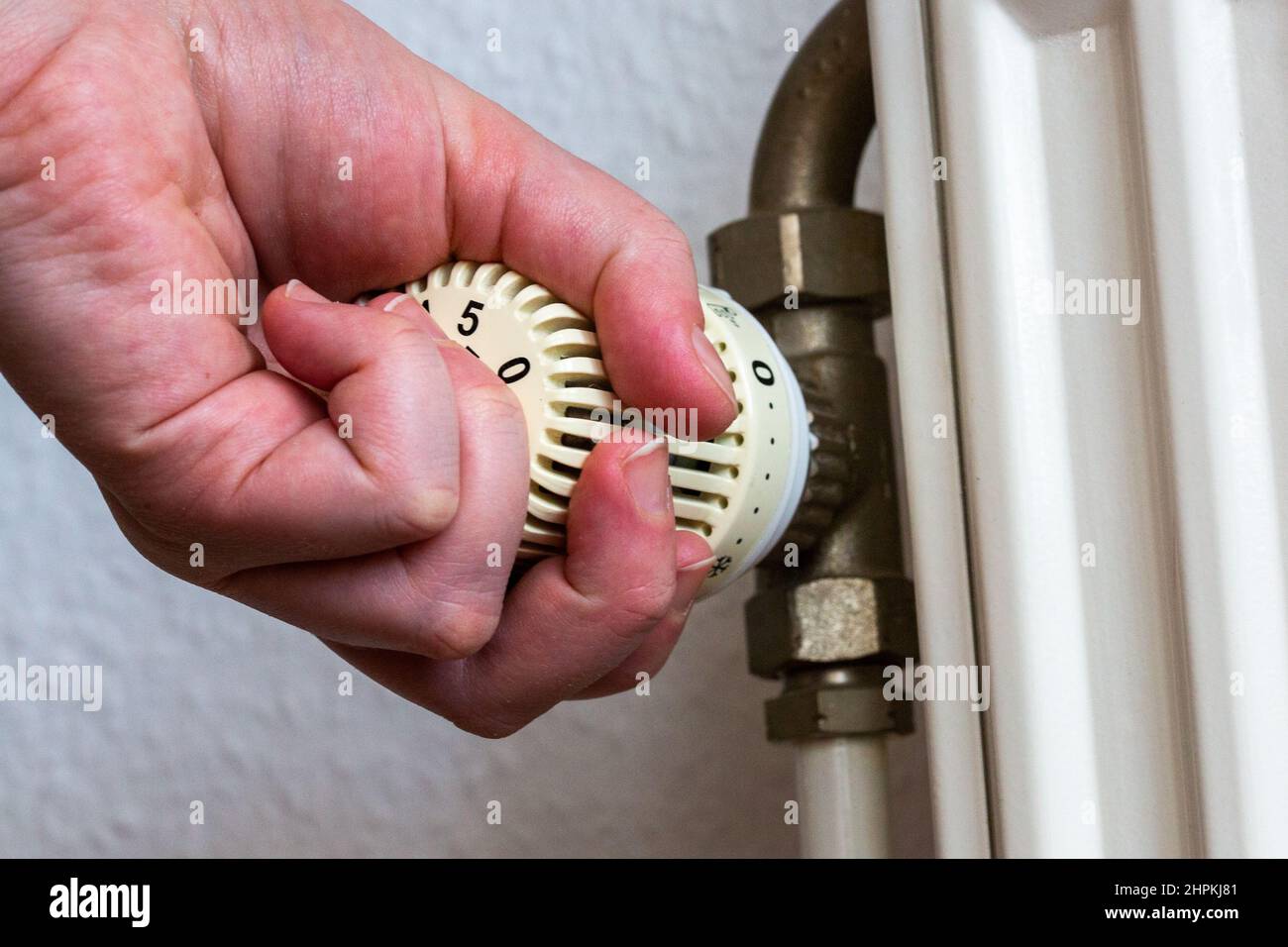 SYMBOL 22 February 2022, Berlin A person turns the thermostat of a