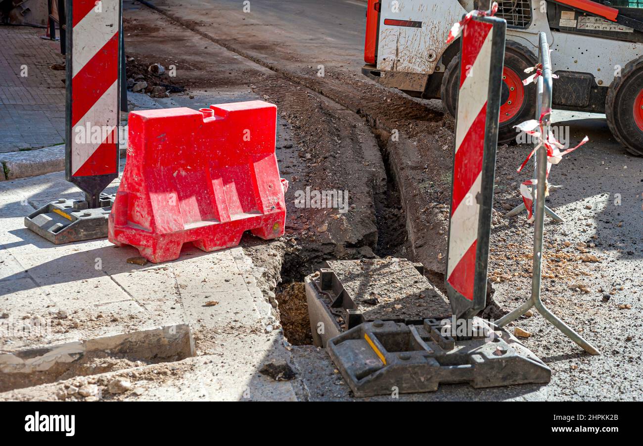 Worker inserts fiber optic cables buried in a micro trench Stock Photo ...