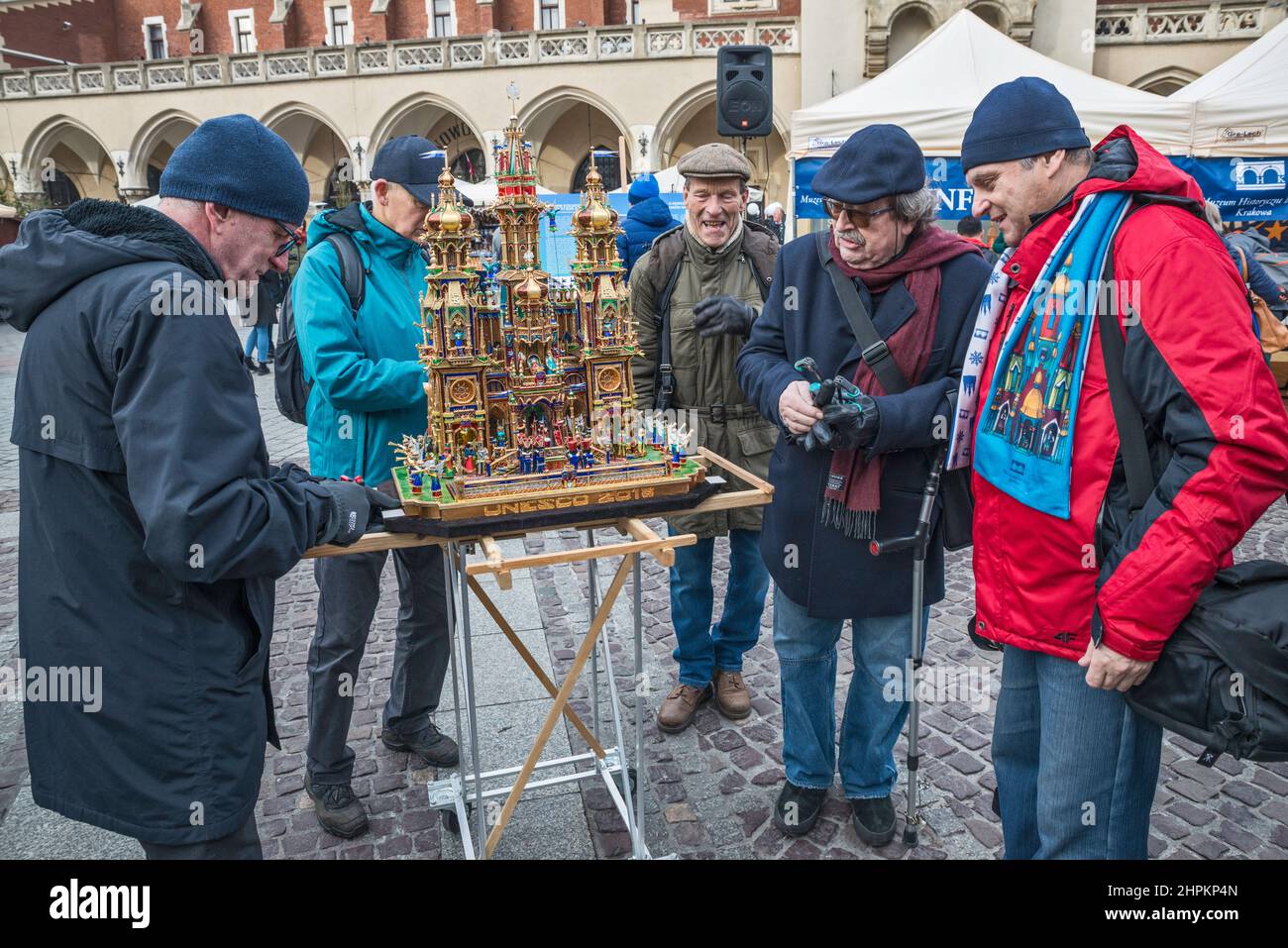 Elderly men bringing Szopka nativity scene for display during annual contest in December, event included in UNESCO Cultural Heritage list, at Adam Mickiewicz monument, Main Market Square, Kraków, Poland Stock Photo