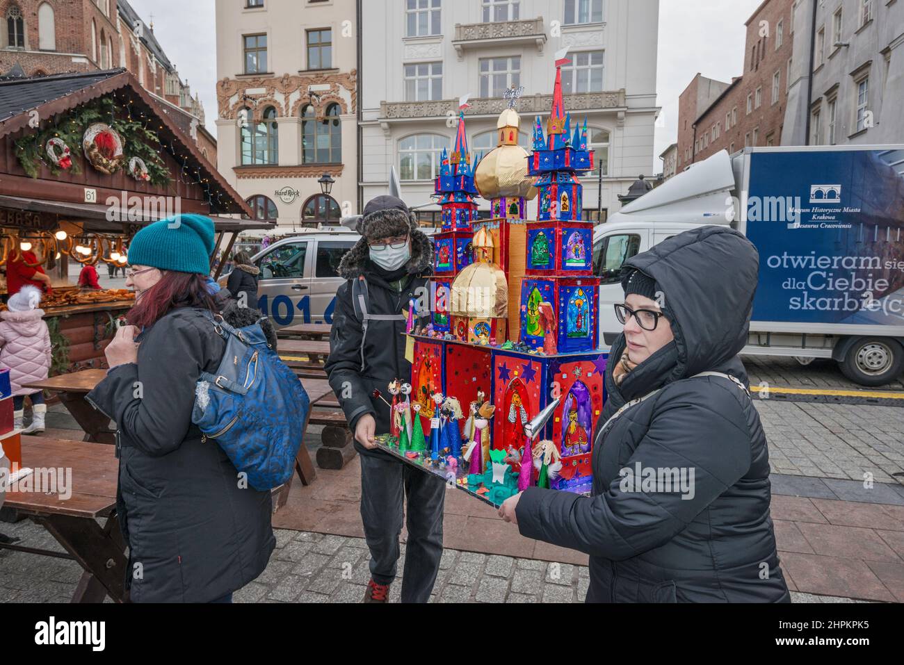Man and woman carrying Szopka nativity scene to display during annual contest in December, event included in UNESCO Cultural Heritage list, at Adam Mickiewicz monument, Main Market Square, Kraków, Poland Stock Photo