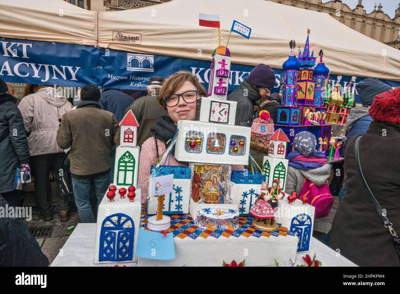 Girl carrying Szopka nativity scene to display during annual contest in December, event included in UNESCO Cultural Heritage list, at Adam Mickiewicz monument, Main Market Square, Kraków, Poland Stock Photo