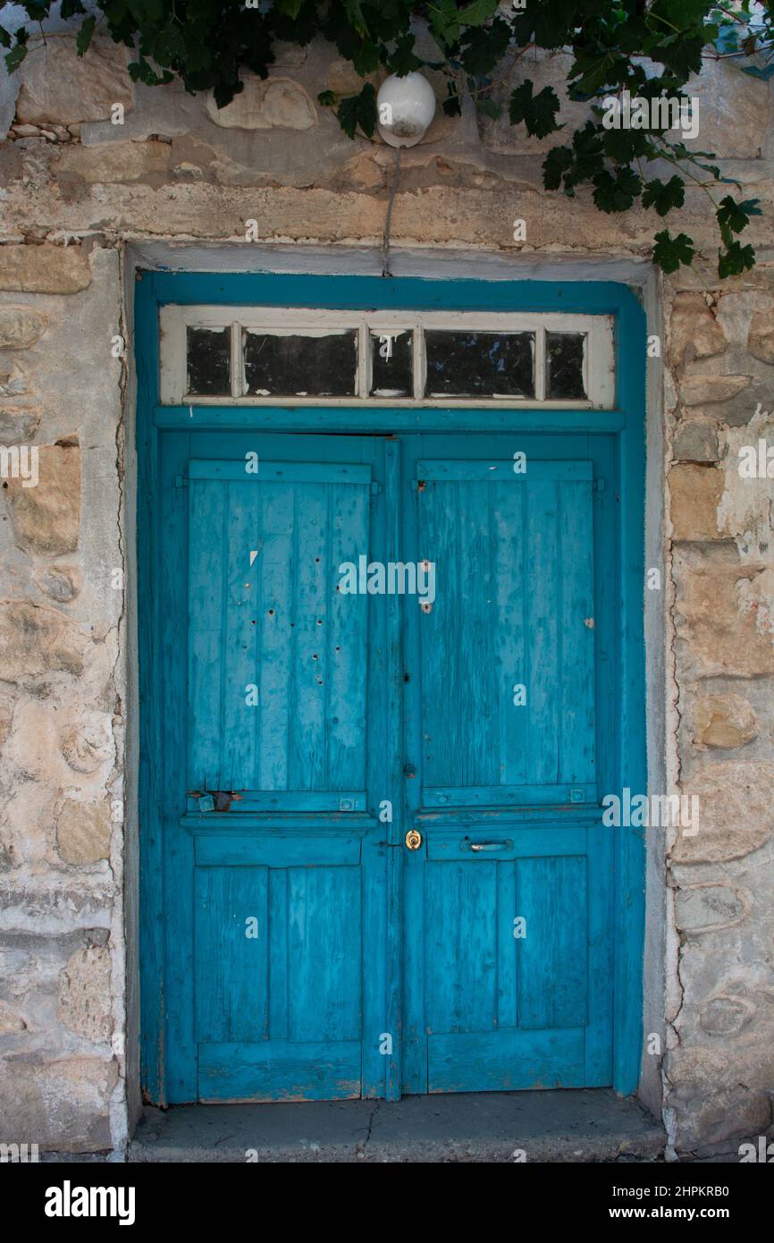 Old blue wooden door in small cypriot village and grapes plant Stock ...