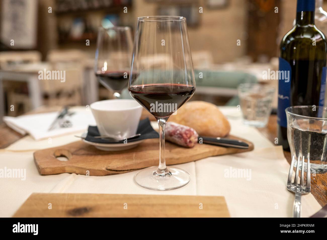 Dinner with glass of dry red wine in Italian osteria restaurant Stock