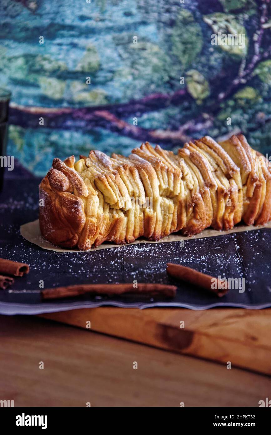 Homemade cinnamon bread with sugar served on black wallpaper with some