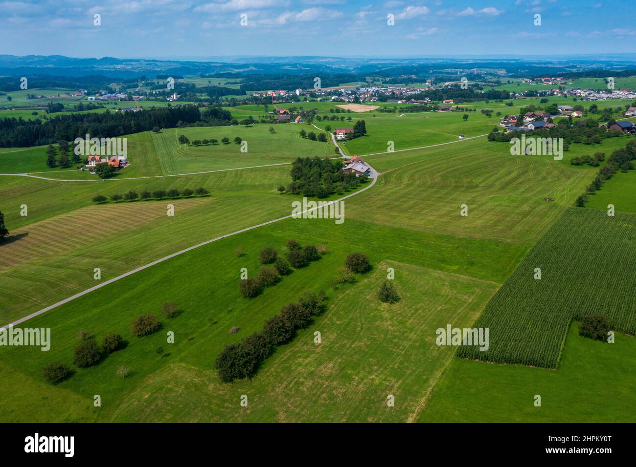 Panorama aerial view of the green Swiss hills on a summers day with blue skies. Nobody inside Stock Photo