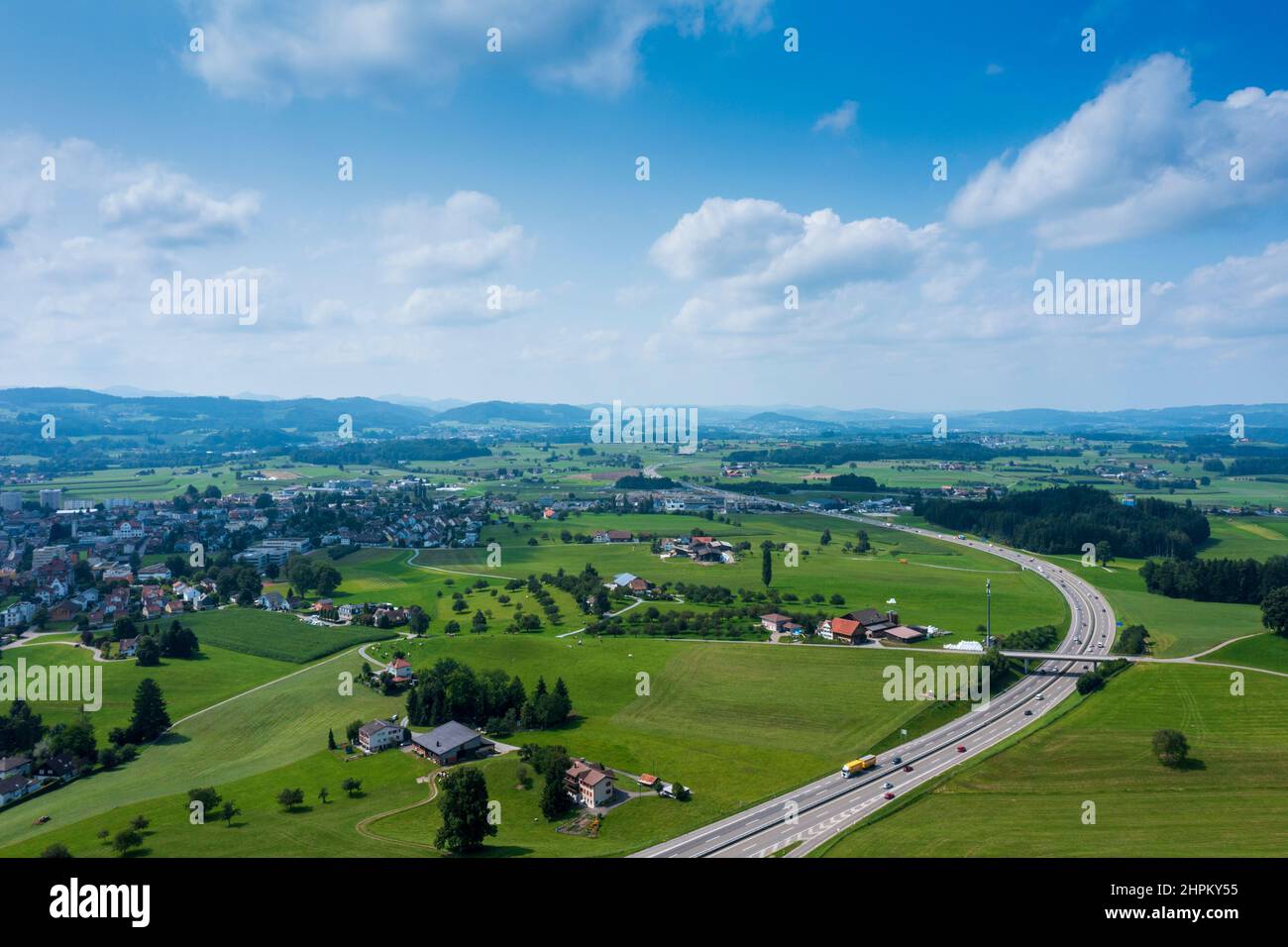 Panorama aerial view of the green Swiss hills on a summers day with blue skies. Nobody inside Stock Photo