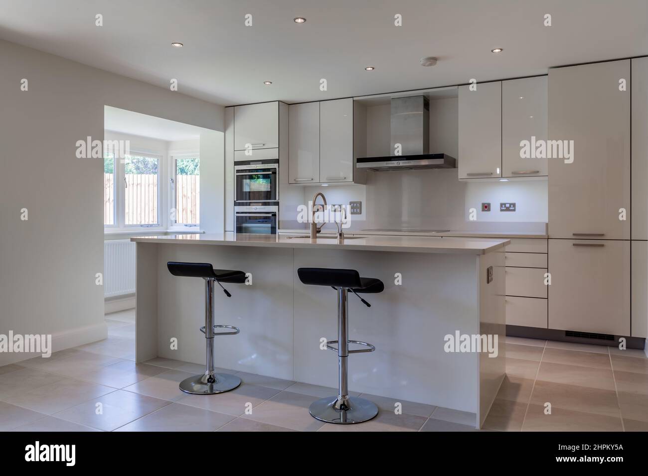 Cambridge, Cambridgeshire - Sept 4 2010: Modern kitchen design with peninsular unit breakfast bar, stools and fitted cabinets with built in appliances Stock Photo