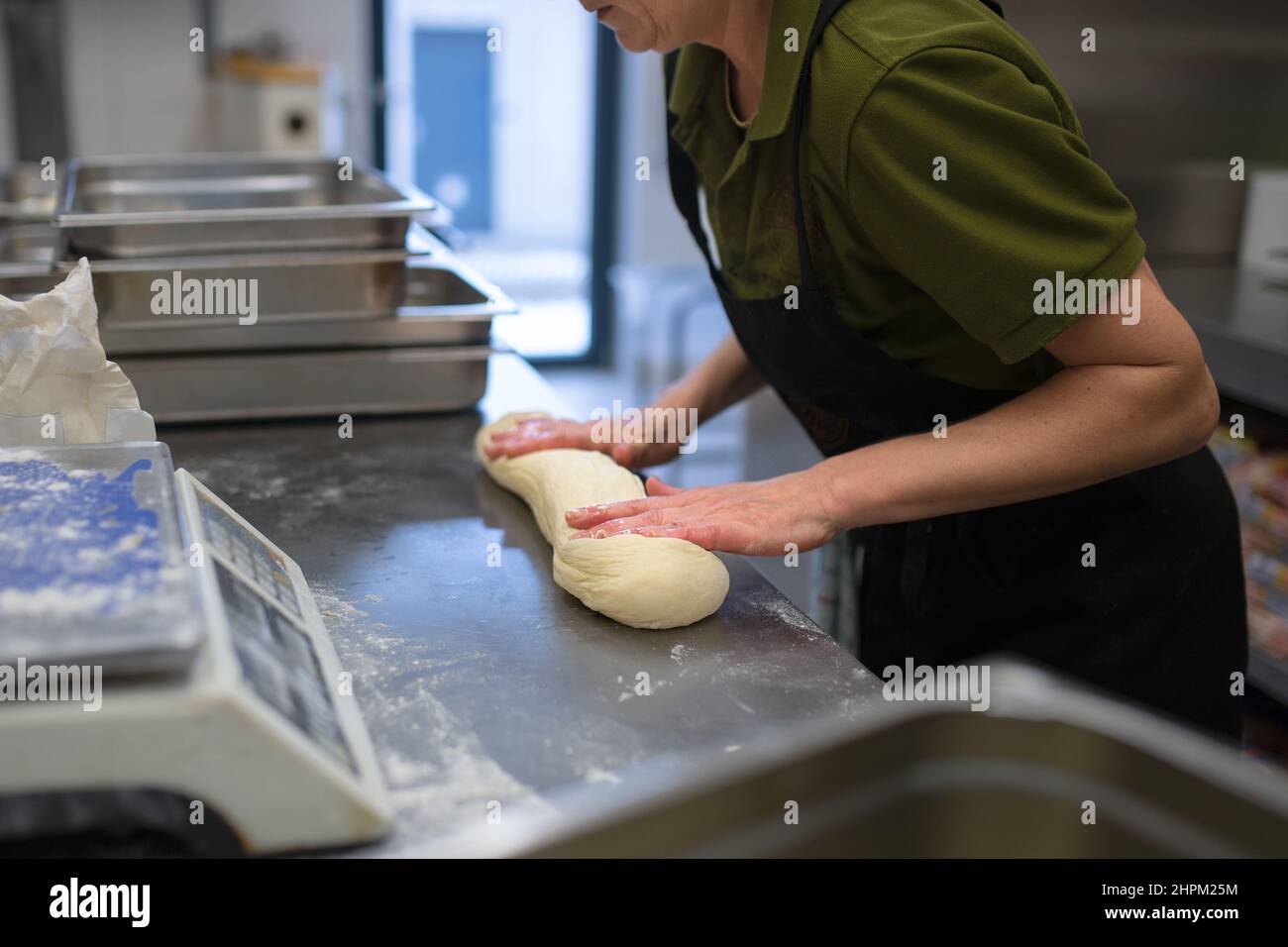 An unrecogniozable chef kneading yeast dough indoors in restaurant