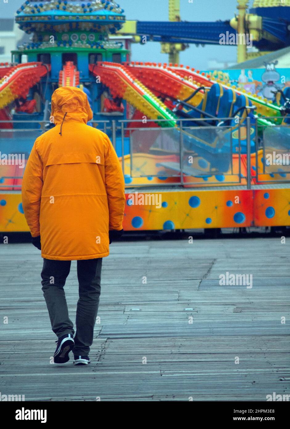 A yellow rain jacket on the pier at Brighton Stock Photo
