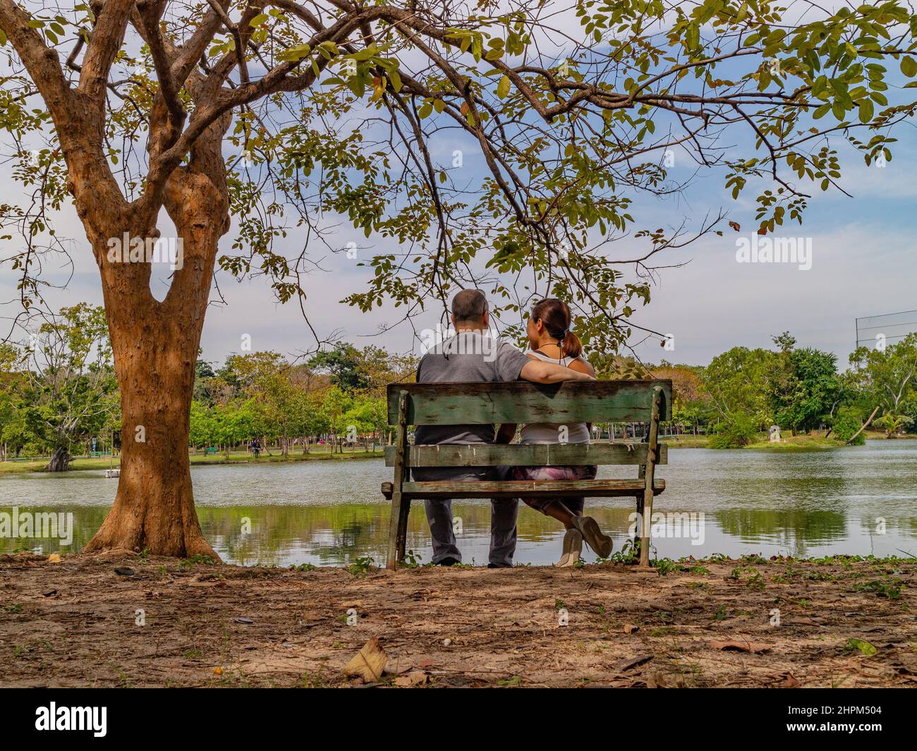 Couple Sitting on a Park Bench Stock Photo - Alamy