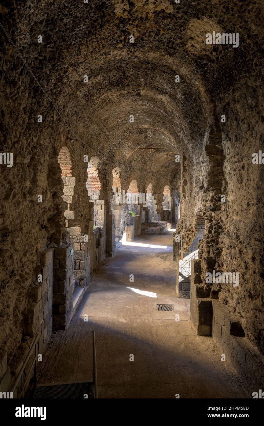 Peripheral underground gallery or vomitorium made out of volcanic stones, curving around the Ancient Roman amphitheater of Catania in Sicily, Italy Stock Photo