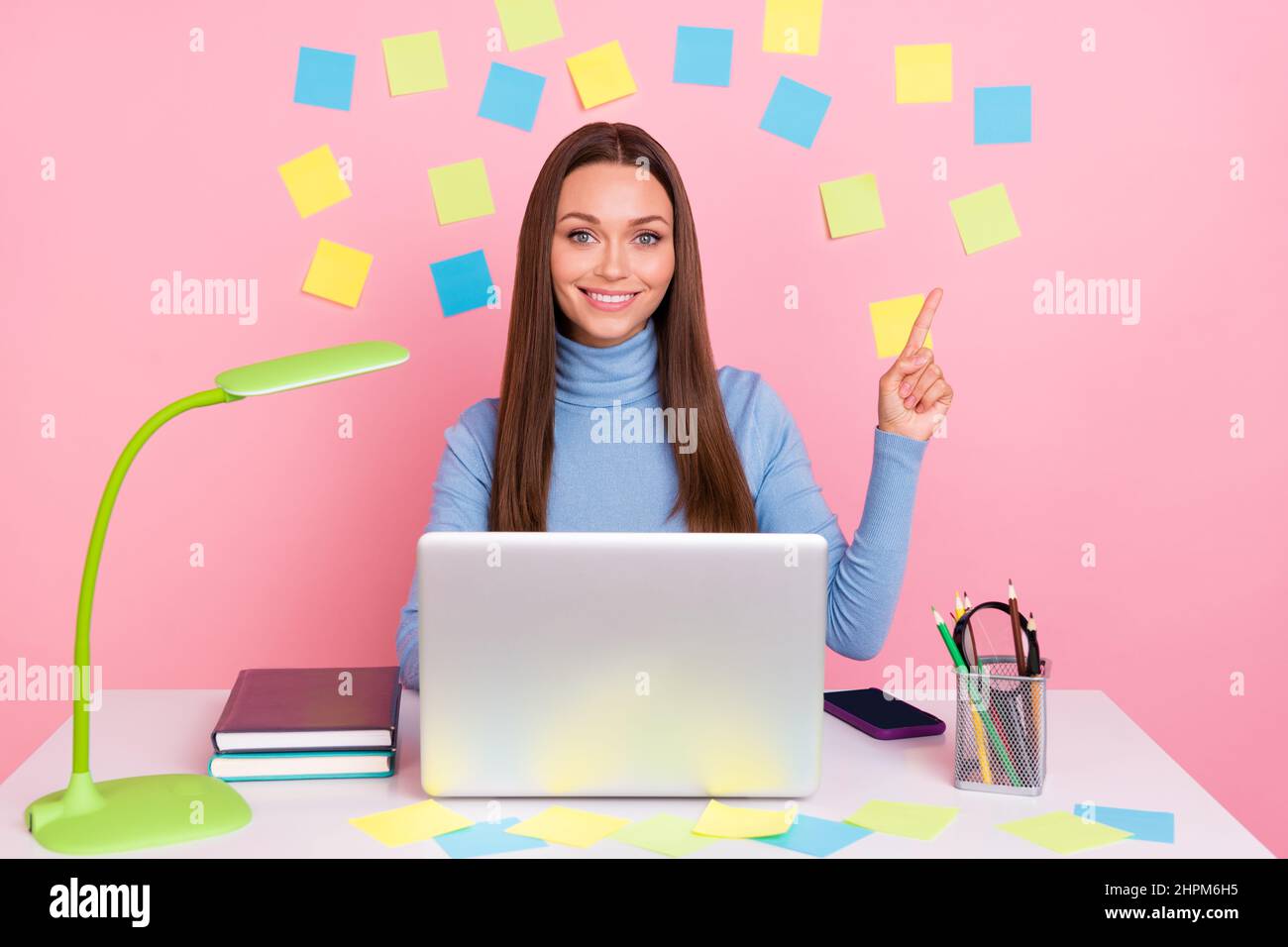 Photo of lady promoter sit desk point hand empty space sticky notes remind deadline netbook isolated on pastel color background Stock Photo