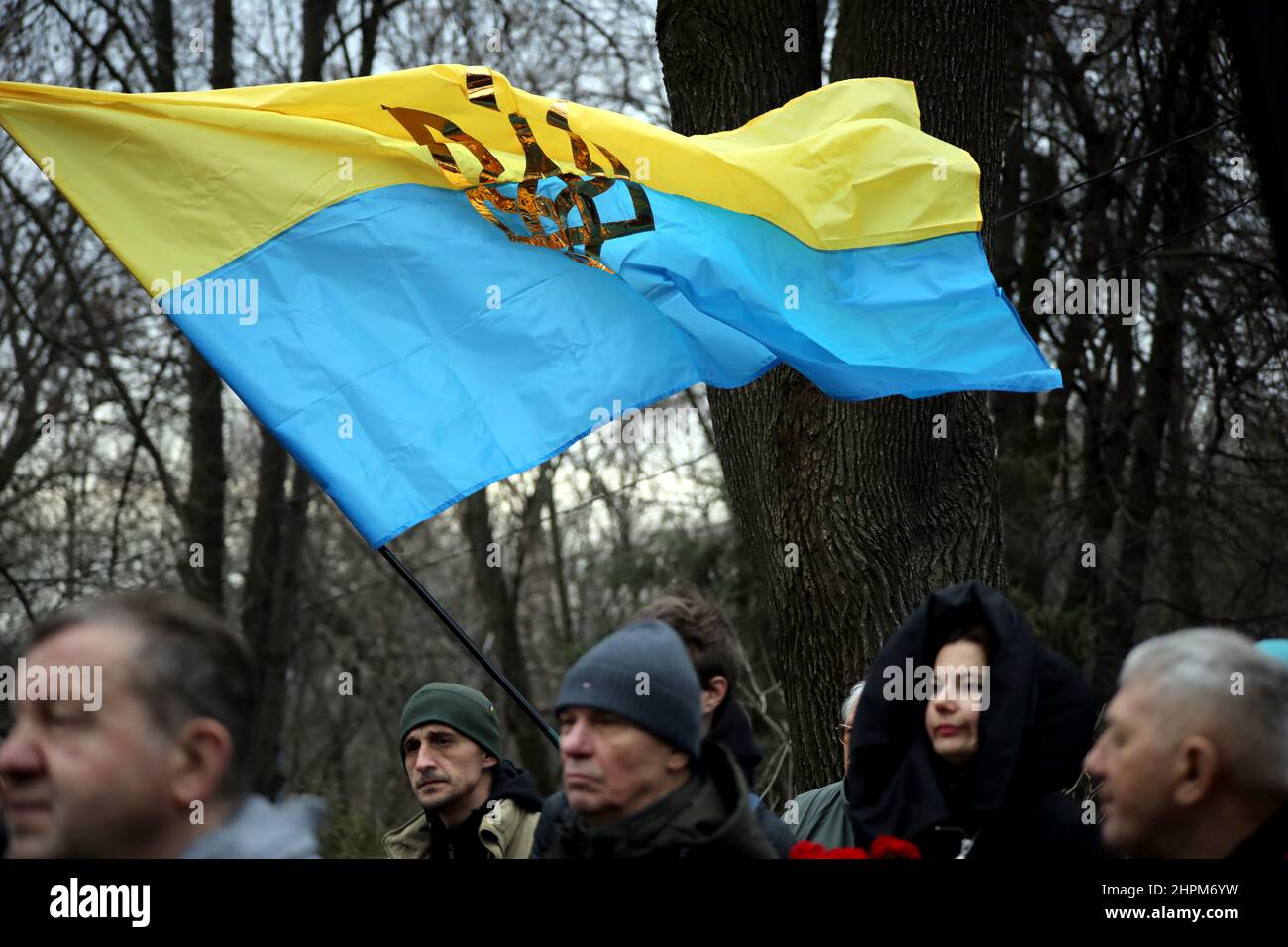 KYIV, UKRAINE - FEBRUARY 19, 2022 - A Ukrainian flag with the tryzub (trident) flies above the people attending the commemorative event for the Debalt Stock Photo