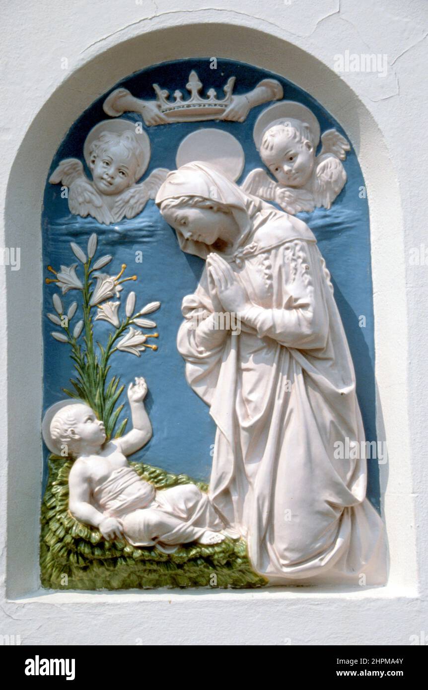 Della Robbia style ceramic Madonna and child with cherubs above wall plaque. Bologna Italy Stock Photo