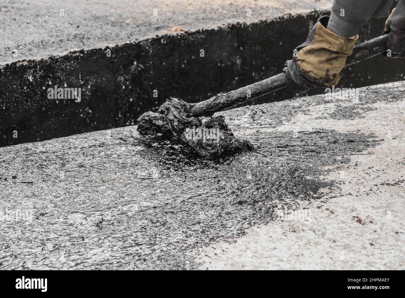 A construction worker is engaged in dirty manual work to repair and