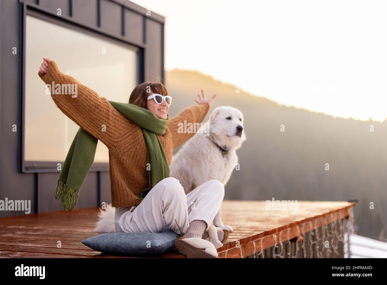 Woman with her dog resting on terrace of tiny house on nature Stock ...