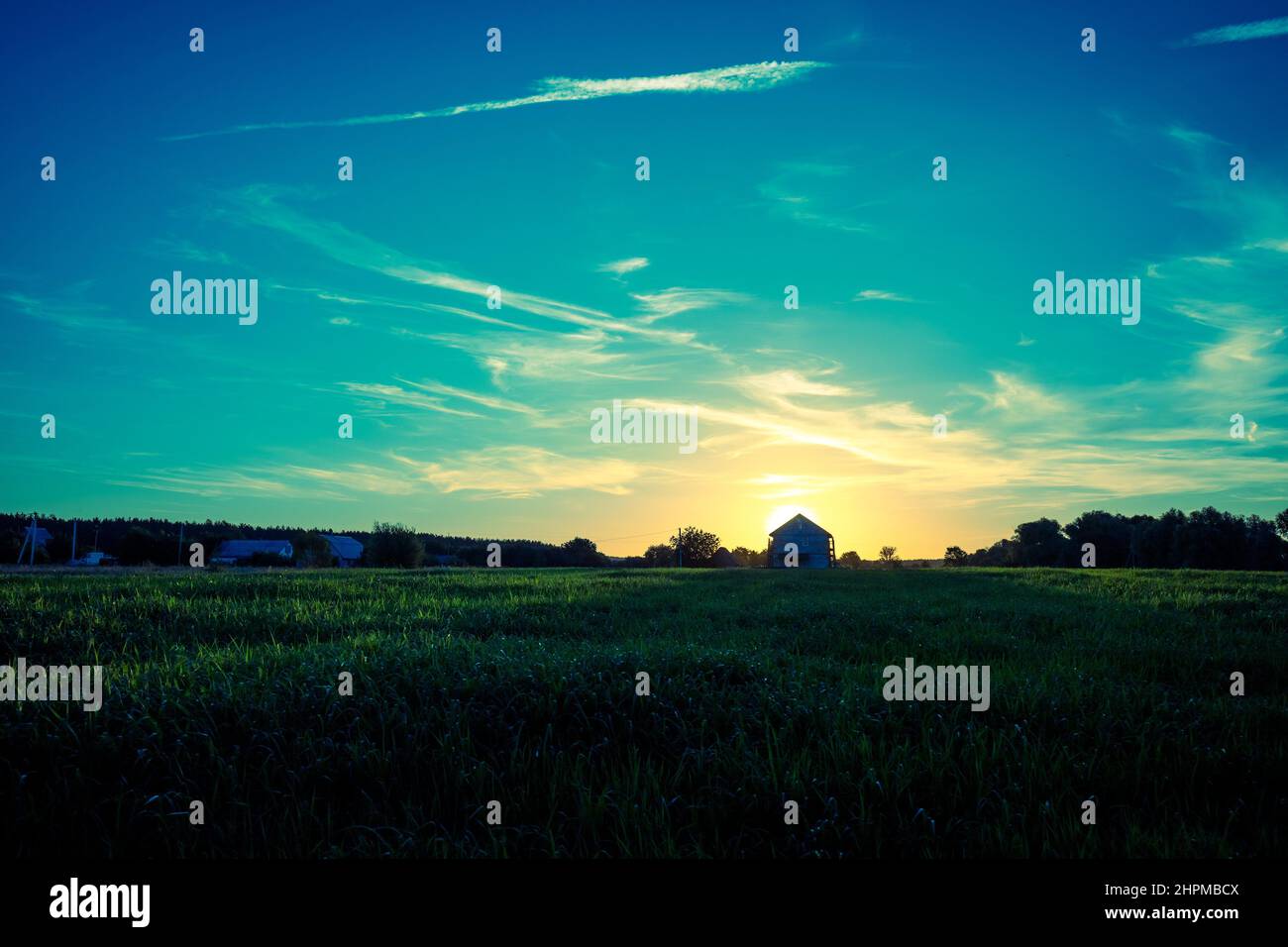 Rural landscape in the evening at sunset. Silhouette of the village against the background of a beautiful gradient evening sky Stock Photo