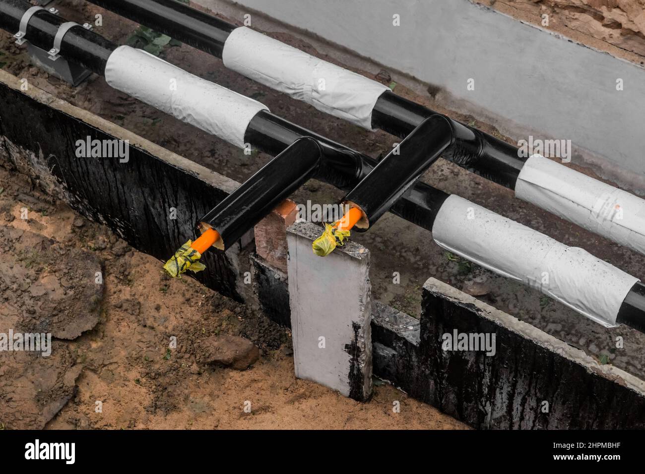 Repair of the water line of the heating main pipe in the ground trench pipeline at the construction site work industry. Stock Photo