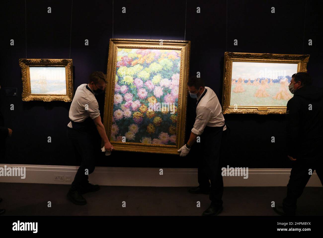 Sotheby's employees move the artwork 'Massif de chrysanthemes, 1897' by