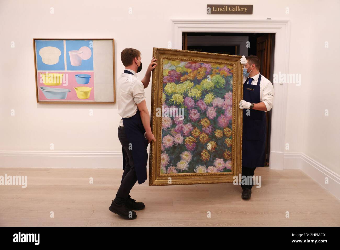 Sotheby's employees move the artwork 'Massif de chrysanthemes, 1897' by