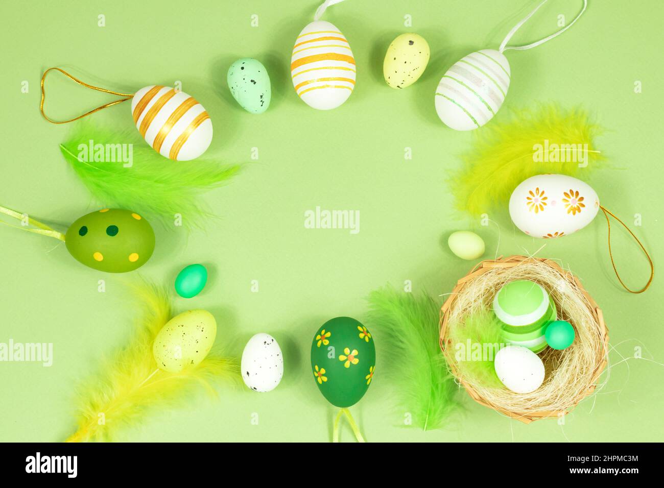 Happy easter. Delicate, pastel salad background with a nest, colorful eggs and feathers. View from above. Place for text. Stock Photo