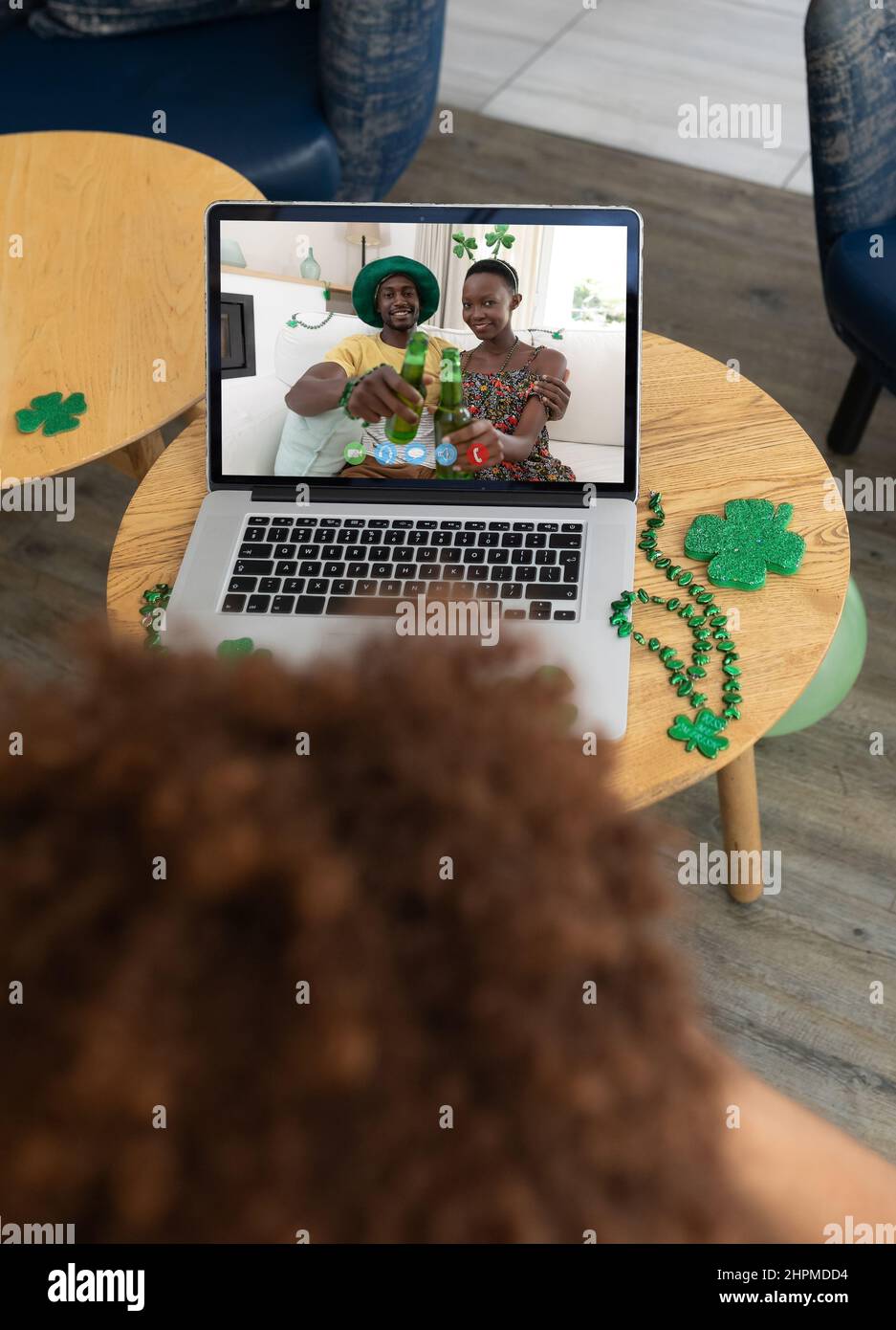 Man at bar making st patrick's day video call with smiling african american couple on laptop Stock Photo