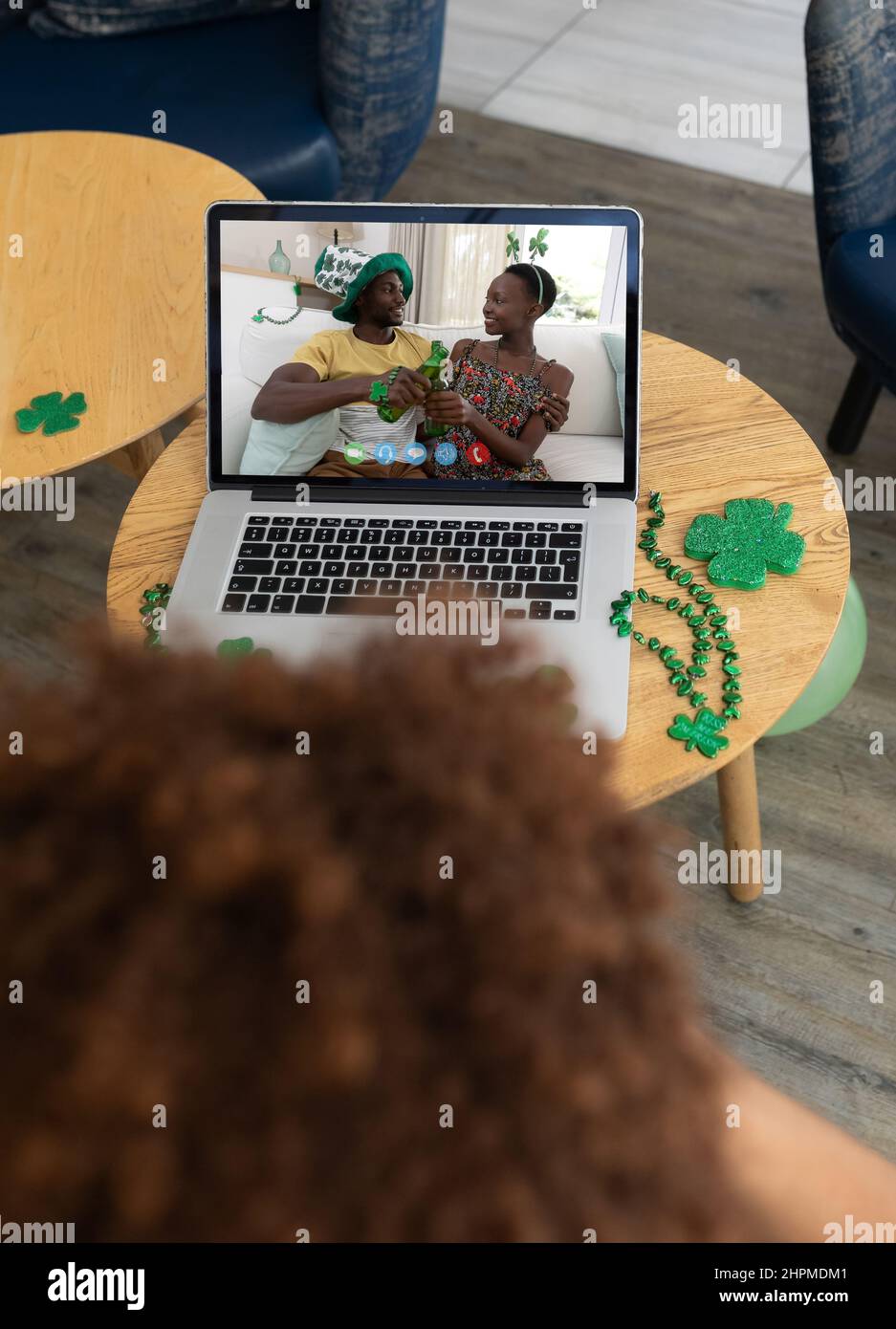Man at bar making st patrick's day video call with happy couple making a toast with beers on laptop Stock Photo