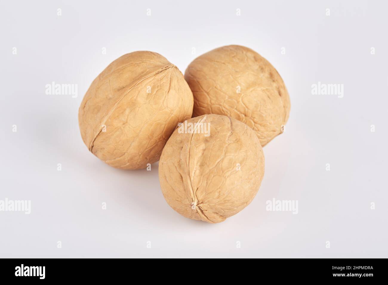 Three walnuts lie side by side on a white background Stock Photo