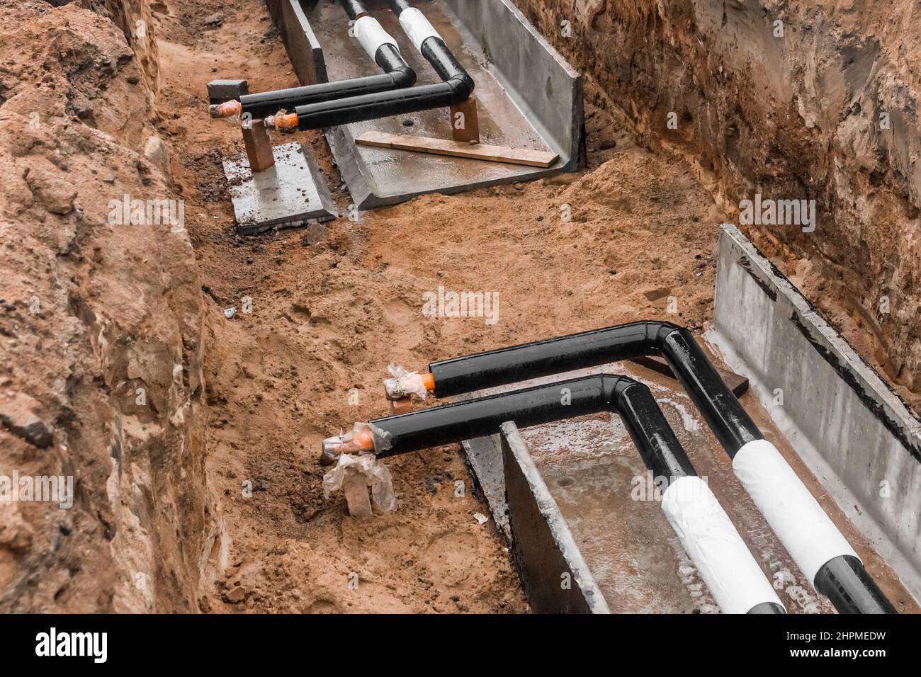 Repair of the water line of the heating main pipe in the ground trench pipeline at the construction site work industry. Stock Photo