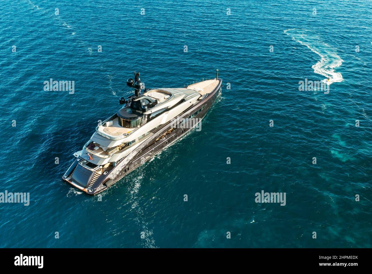 ROVINJ, CZECH REPUBLIC - JULY 03 2021: Luxurious yacht drifts in Adriatic sea illuminated by bright sunlight reflected from water. Calm sea rippling water with small waves. Upper view Stock Photo